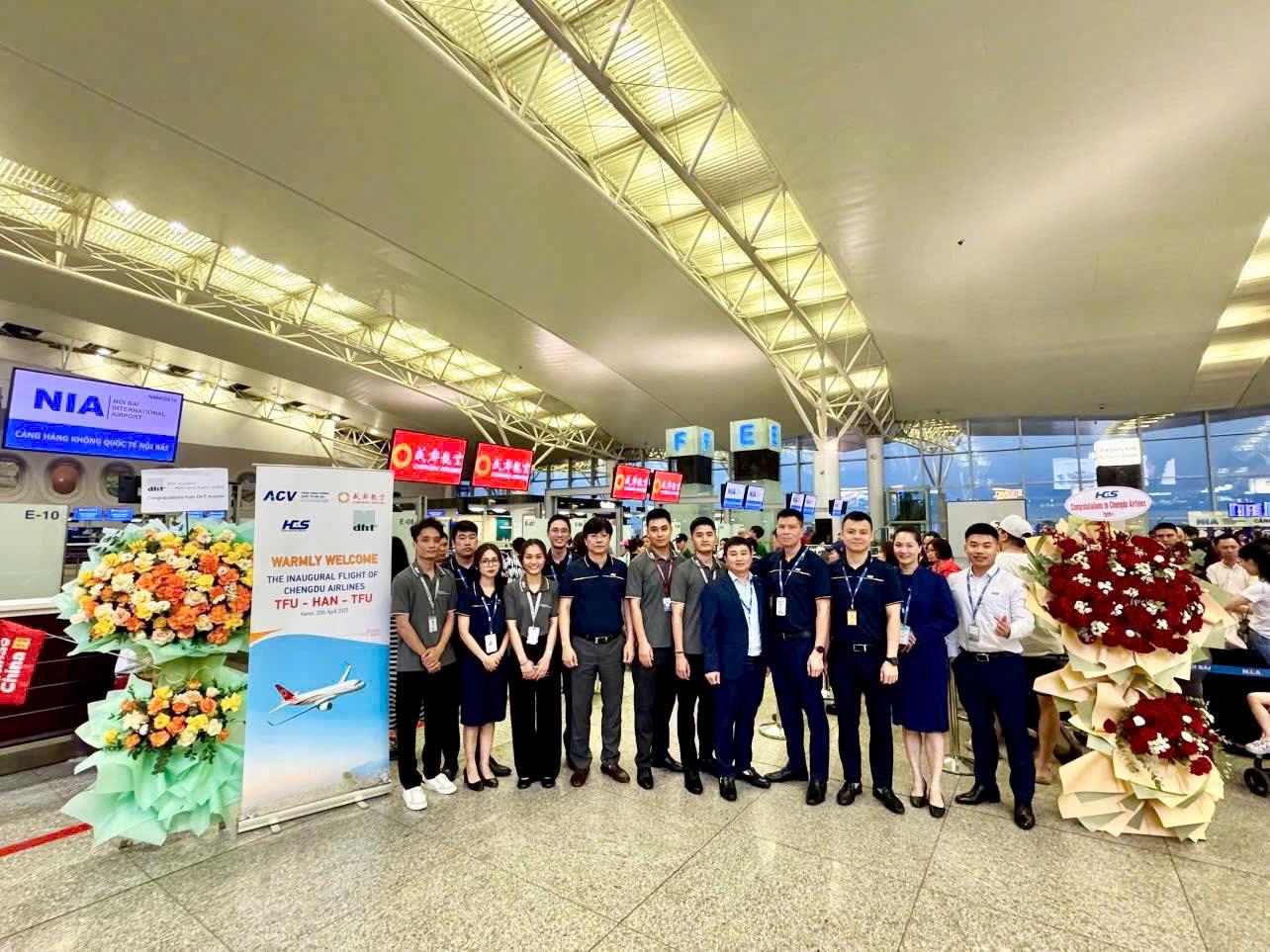 A group of people standing in a room with flowers and signsAI-generated content may be incorrect.