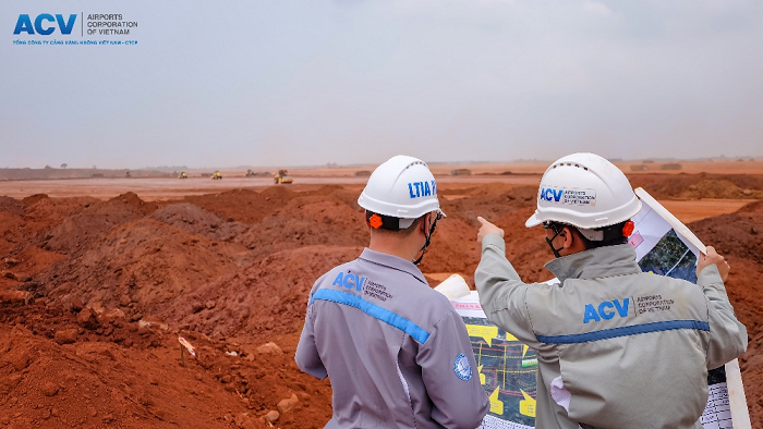 A couple of men wearing hard hatsDescription automatically generated